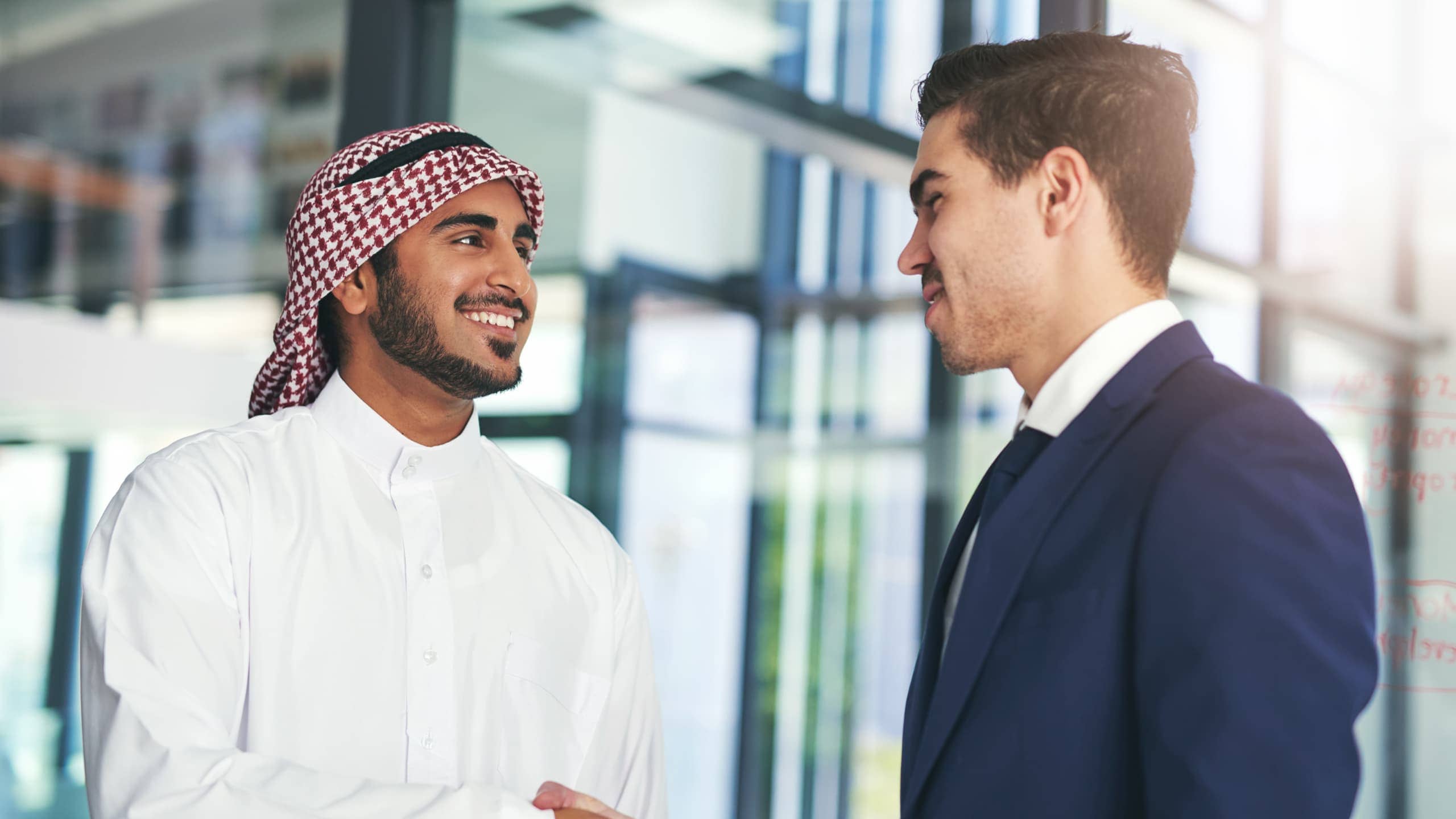 Two men shaking hands in a professional setting.
