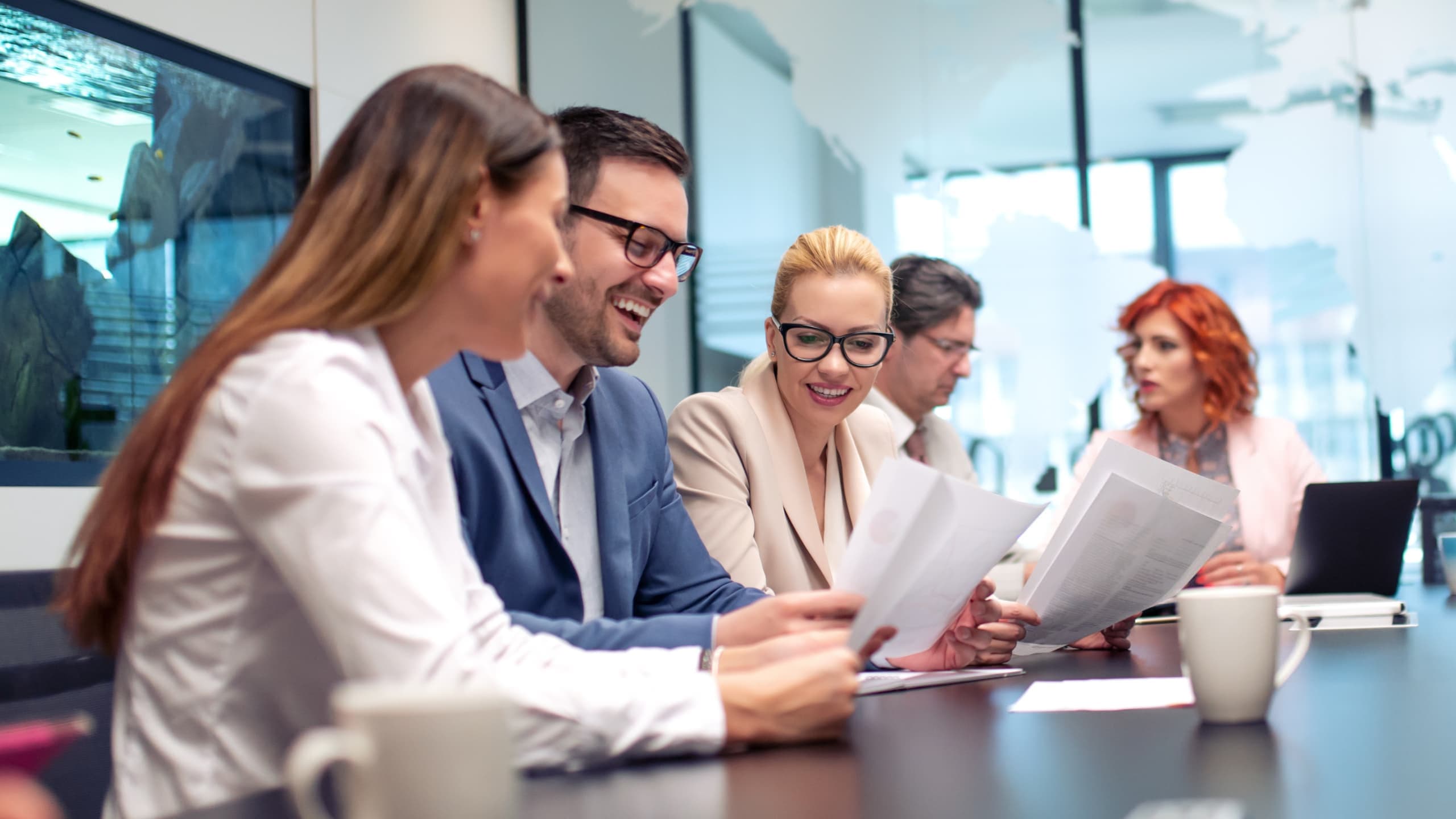 Group of people having a meeting around a conference table.