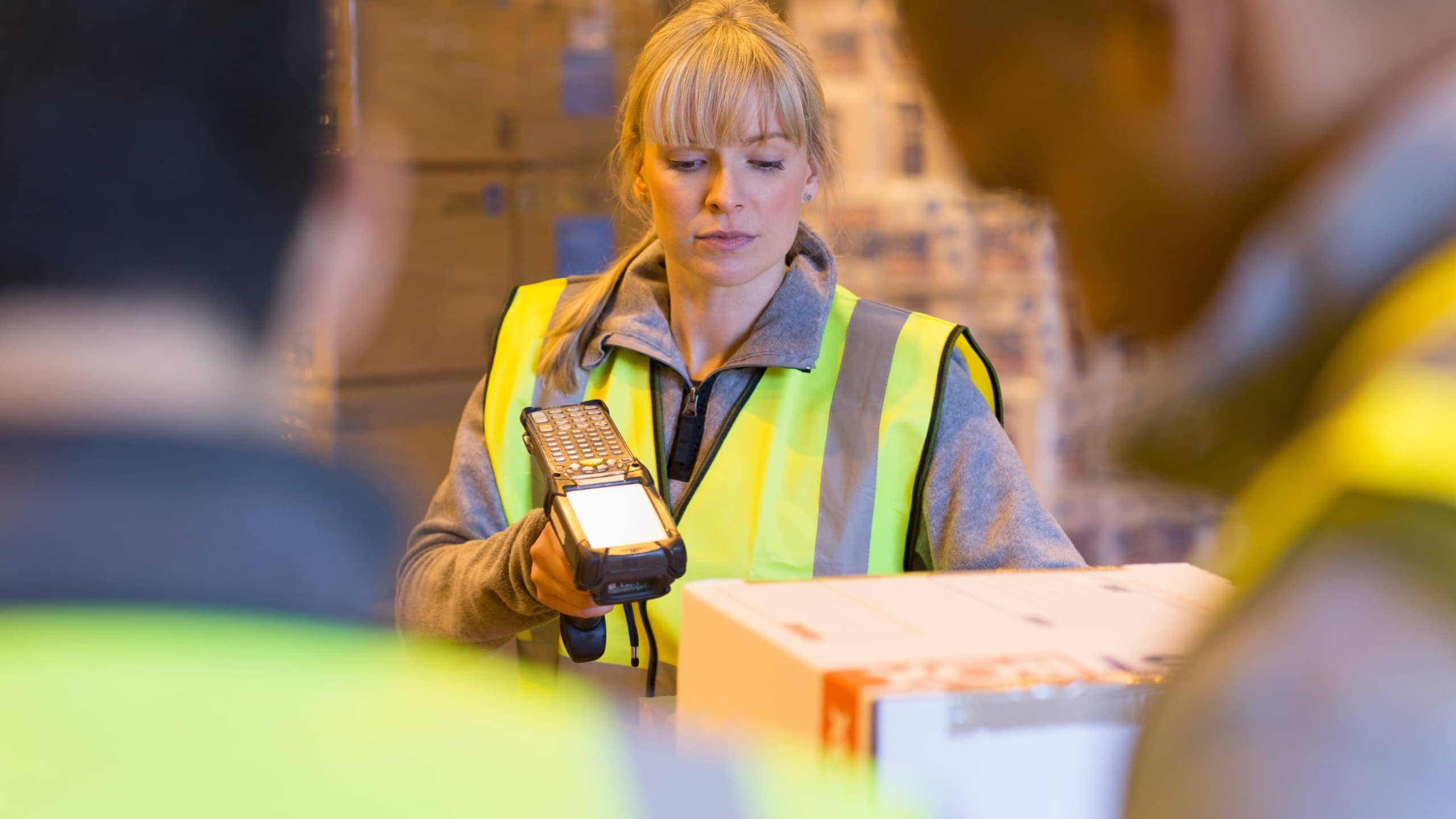 Woman using a handheld scanner in a warehouse.