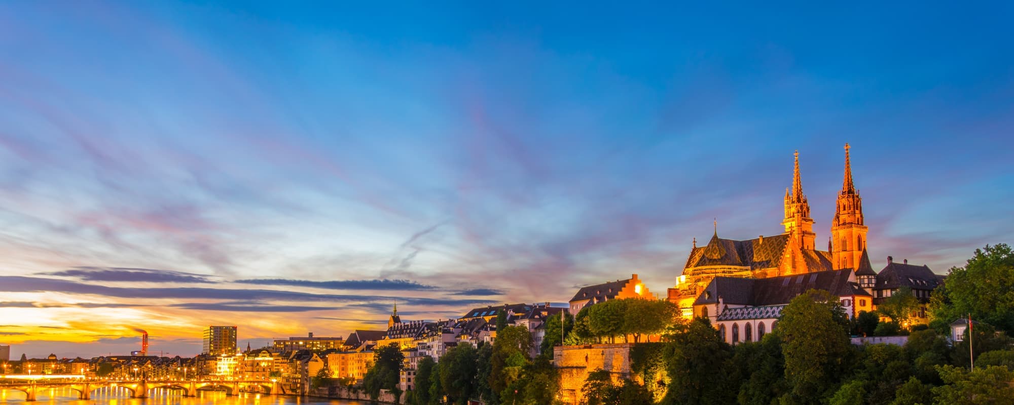 Sunset cityscape with a cathedral and river,
