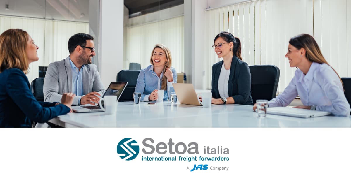 A group of five people sitting around a conference table in a meeting.