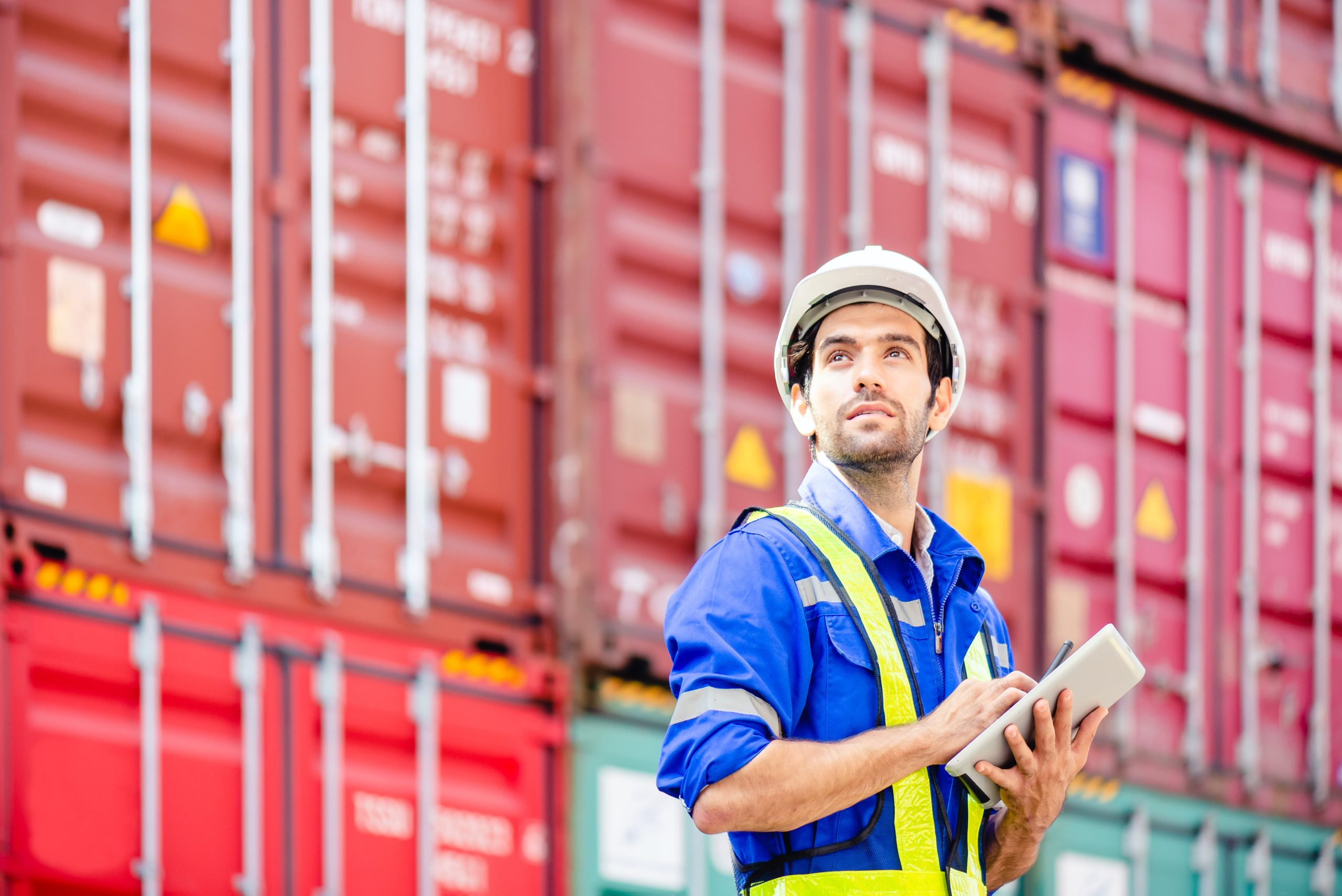 Man in front of red shipping containers